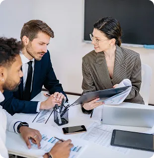 Financial advisers reviewing client documents in a meeting